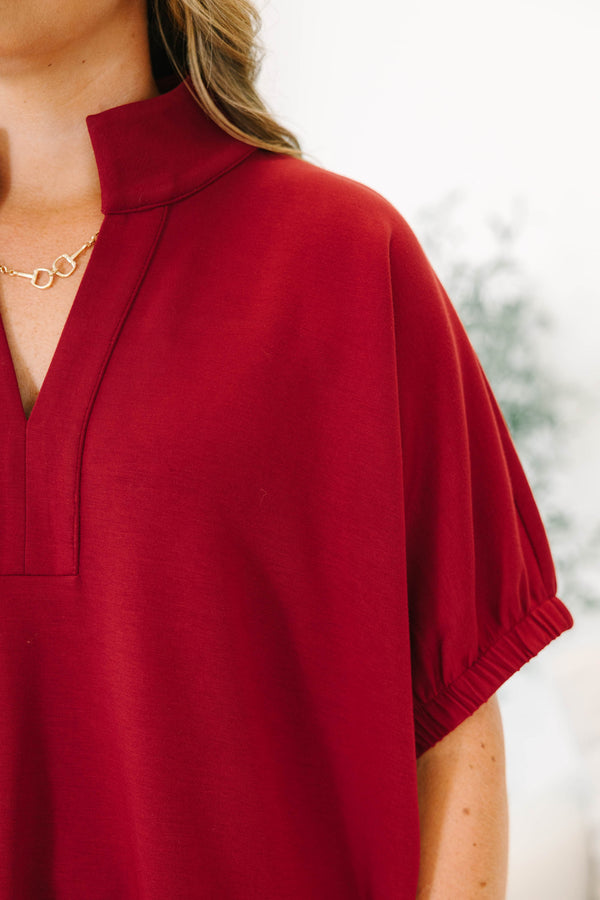 Plus Size cabernet red top with a v-neckline, relaxed fit, and short elasticized sleeves.