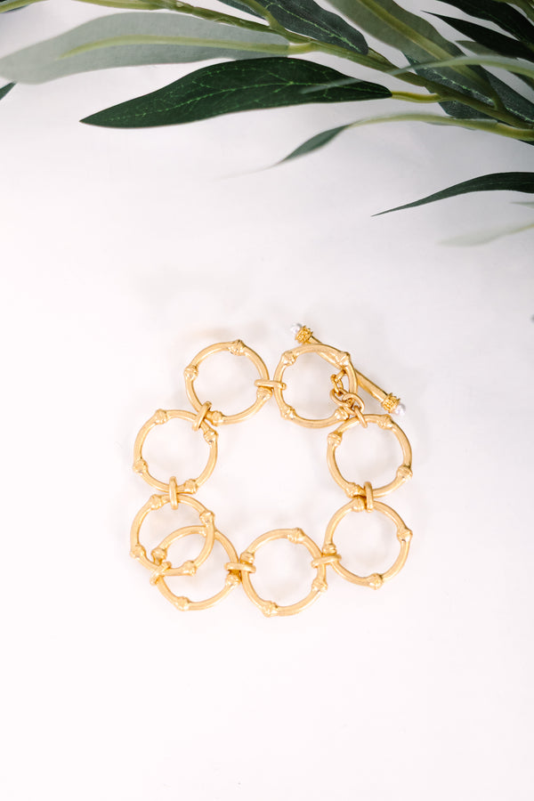 Gold link bracelet featuring a textured bamboo-inspired circular design.