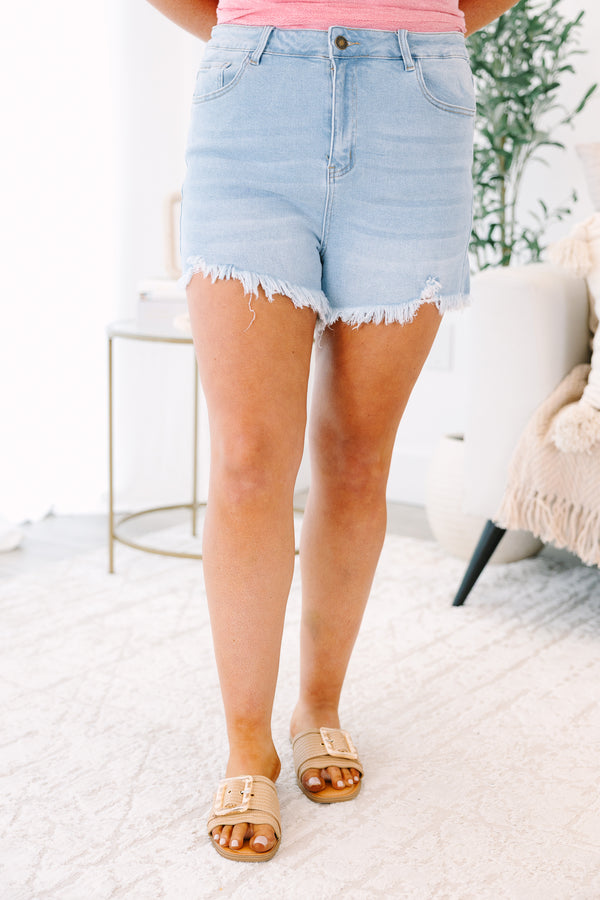 Plus Size light wash denim shorts with a high-rise fit and frayed, raw-edge hems.