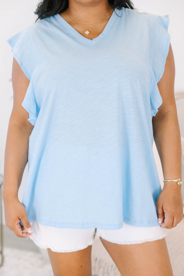 Plus Size light blue V-neck top with flutter sleeves and white frayed denim shorts.