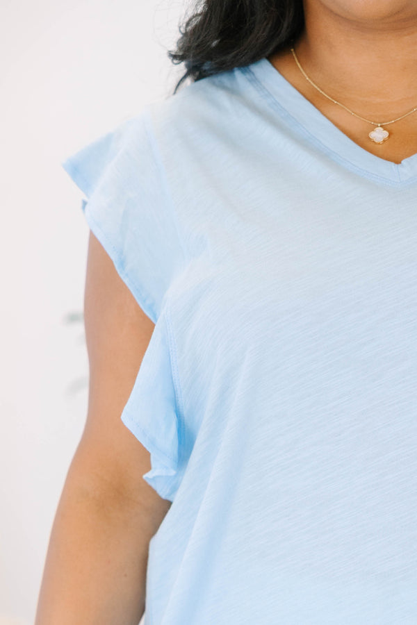 Plus Size light blue V-neck top with flutter sleeves and white frayed denim shorts.