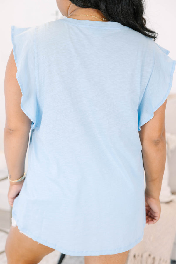 Plus Size light blue V-neck top with flutter sleeves and white frayed denim shorts.