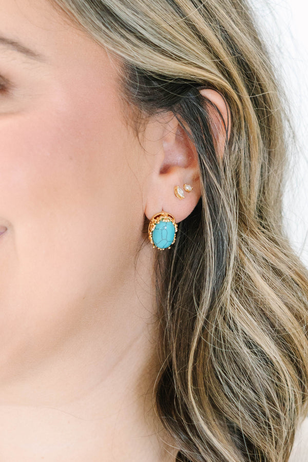 Turquoise Trails Earrings, featuring an oval turquoise stone in a gold-toned setting.