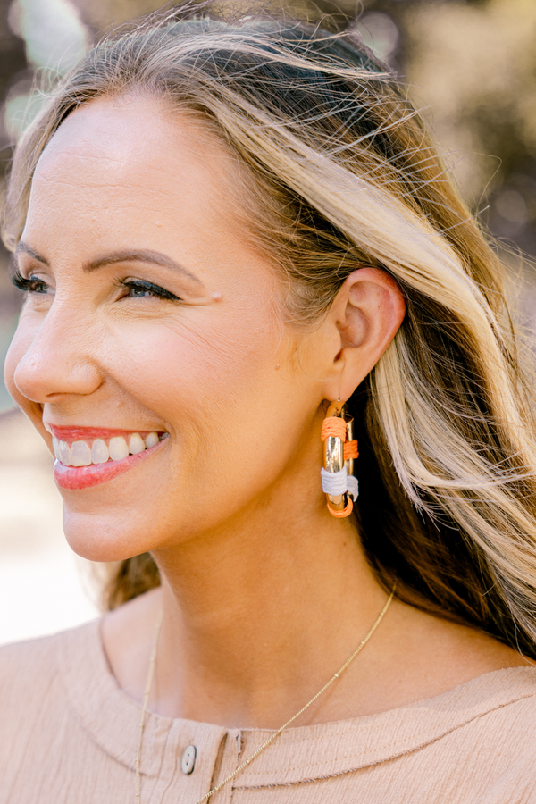 Chic Soul plus size clothing, gold hoop earrings with orange and white woven segments on each earring 