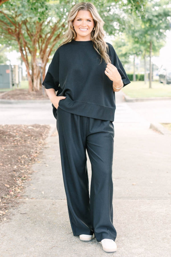 Plus size black ribbed knit lounge set with a boxy short sleeve top and matching pants.