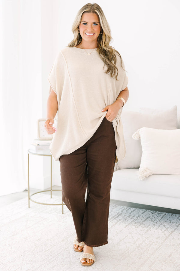 Plus size dark brown wide leg jeans with a raw hem and stretchy cotton fabric.