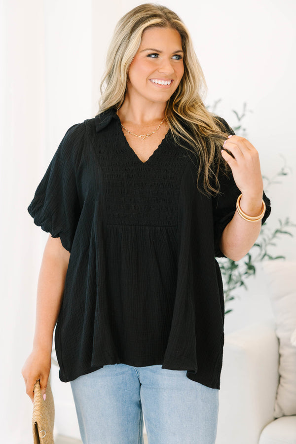 Plus size black cotton top with a flowy fit, smocked bodice, and puff sleeves.