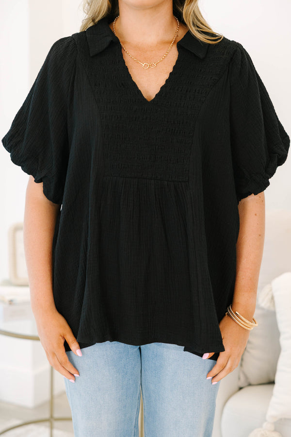 Plus size black cotton top with a flowy fit, smocked bodice, and puff sleeves.