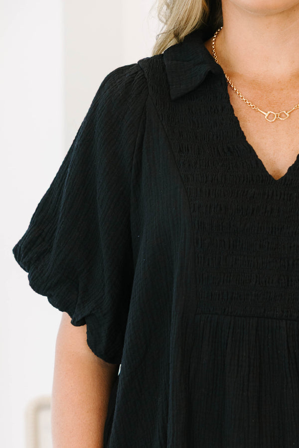 Plus size black cotton top with a flowy fit, smocked bodice, and puff sleeves.