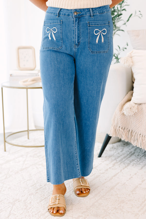 Plus Size wide-leg blue jeans with front patch pockets featuring white bow embroidery.