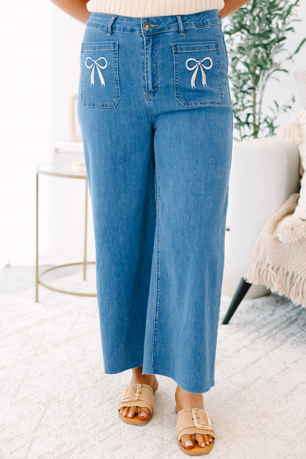 Plus Size wide-leg blue jeans with front patch pockets featuring white bow embroidery.