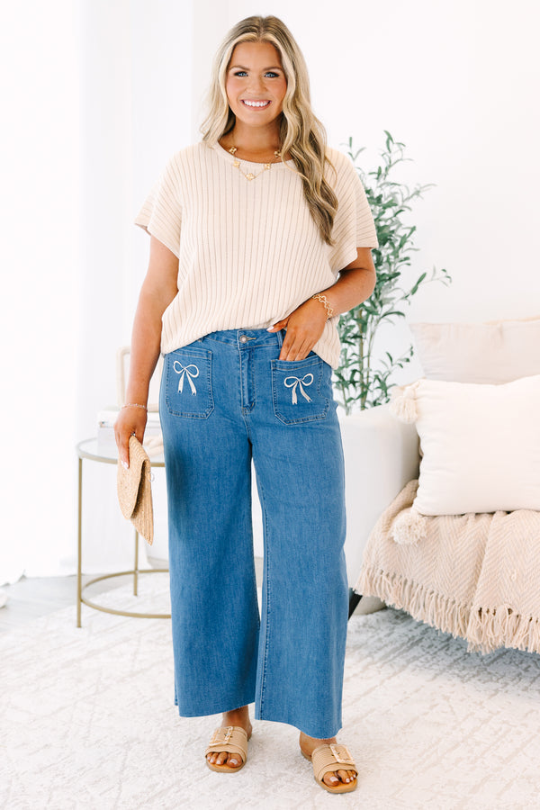 Plus Size wide-leg blue jeans with front patch pockets featuring white bow embroidery.