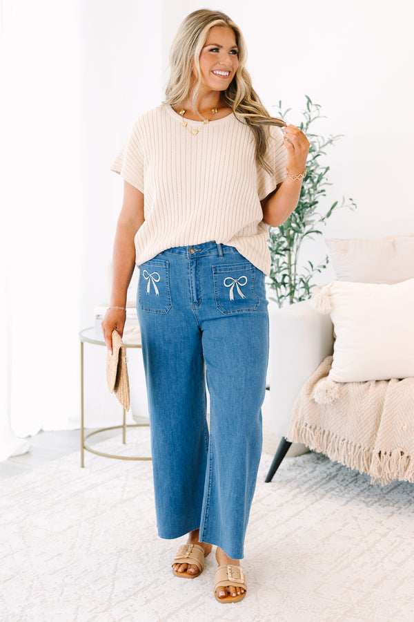 Plus Size wide-leg blue jeans with front patch pockets featuring white bow embroidery.