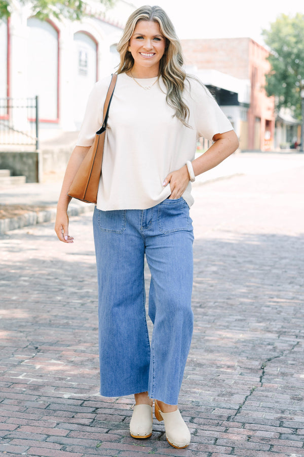 Plus Size medium wash wide leg cropped jeans with front patch pockets and a frayed hemline.