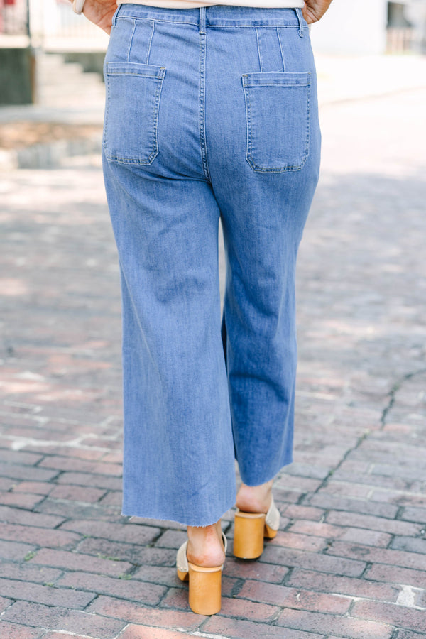 Plus Size medium wash wide leg cropped jeans with front patch pockets and a frayed hemline.