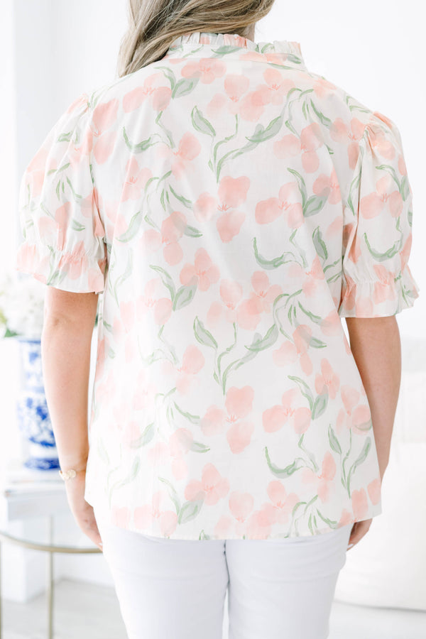 Plus Size pink floral v-neck top with short bubble sleeves and a woven straw clutch.