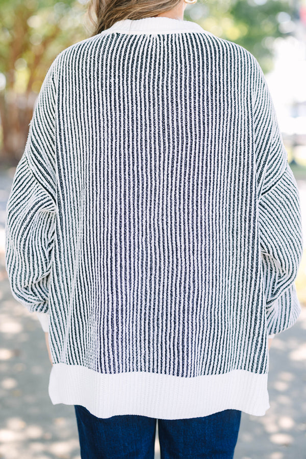Plus Size oversized black and white vertical striped knit sweater with a crew neck and ribbed trim.