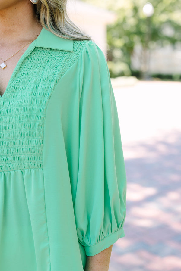 Plus size green flowy top with smocked bodice, V-neck, and balloon sleeves for a feminine fit.