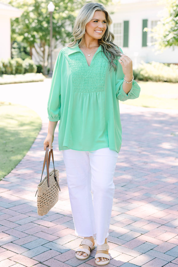 Plus size green flowy top with smocked bodice, V-neck, and balloon sleeves for a feminine fit.