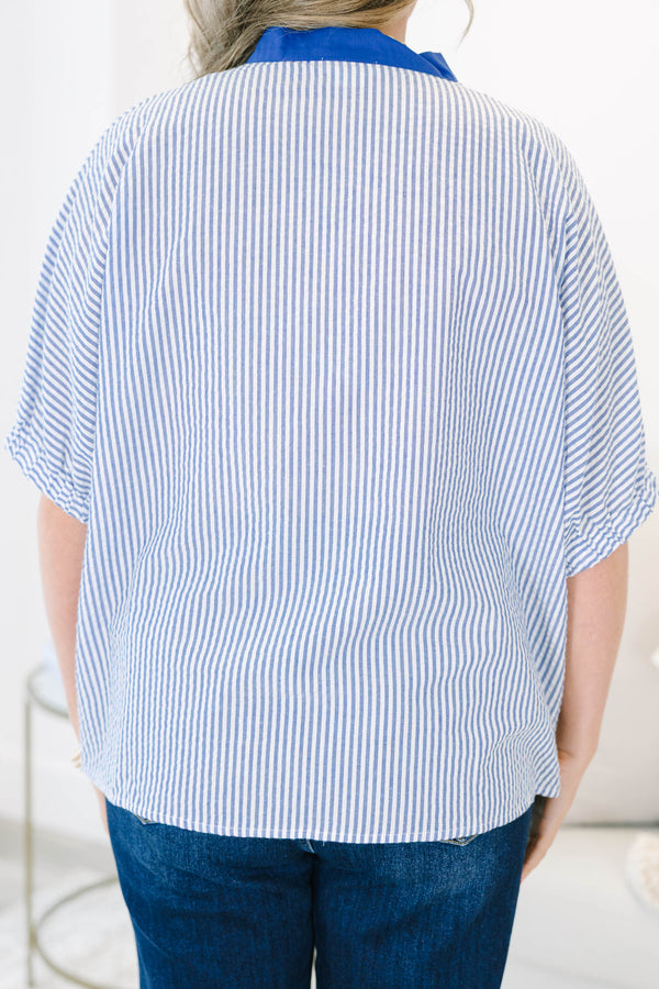 Blue and white vertical striped popover top featuring a bold royal blue contrast V-neck collar trim.