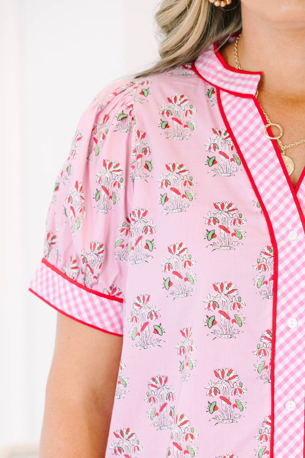 Plus size pink floral top with gingham trim, puff sleeves, and a button-down v-neckline.