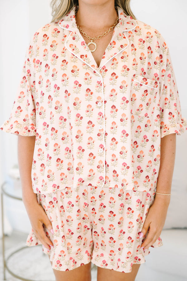 Plus Size cream floral pajama set with a button-down short sleeve top and matching ruffled shorts.