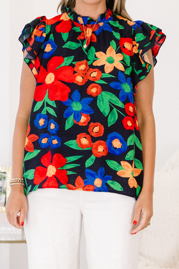 Plus Size navy floral top with flutter sleeves, a ruffled neckline, and colorful flower patterns.