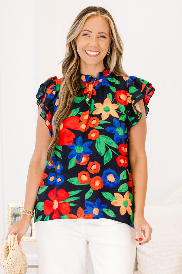 Plus Size navy floral top with flutter sleeves, a ruffled neckline, and colorful flower patterns.