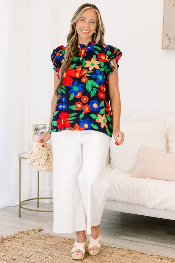 Plus Size navy floral top with flutter sleeves, a ruffled neckline, and colorful flower patterns.