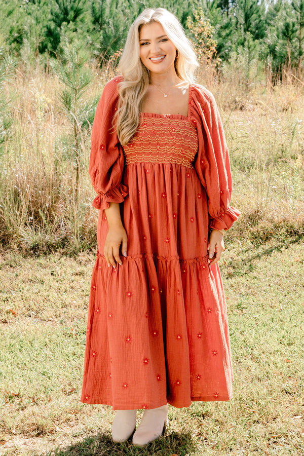 Chic Soul plus size clothing, rust orange long sleeve maxi dress with tiered skirt, embroidered dark orange flowers, and light yellow and orange stitching through stretchy top