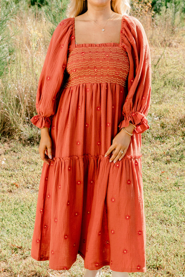 Chic Soul plus size clothing, rust orange long sleeve maxi dress with tiered skirt, embroidered dark orange flowers, and light yellow and orange stitching through stretchy top