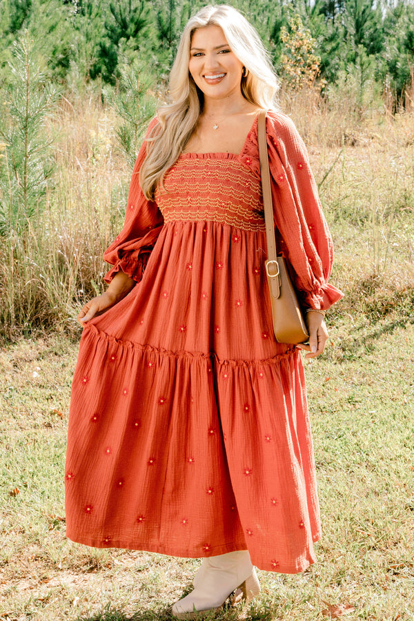 Chic Soul plus size clothing, rust orange long sleeve maxi dress with tiered skirt, embroidered dark orange flowers, and light yellow and orange stitching through stretchy top
