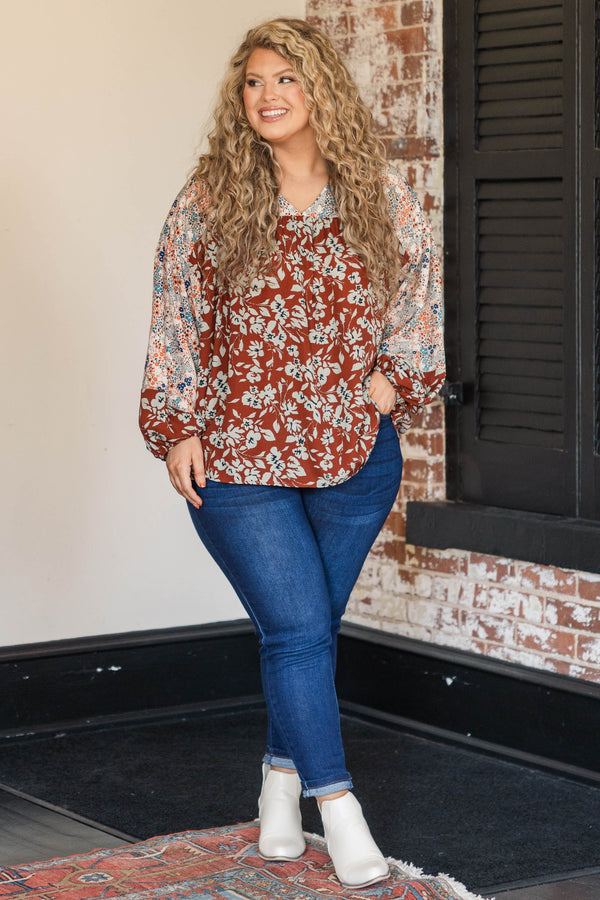 Chic Soul plus size clothing, rust colored top with floral patterned sleeves and larger floral detailing along the bodice
