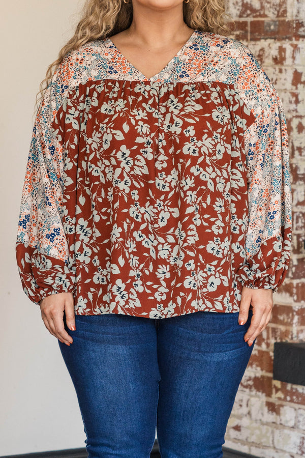 Chic Soul plus size clothing, rust colored top with floral patterned sleeves and larger floral detailing along the bodice