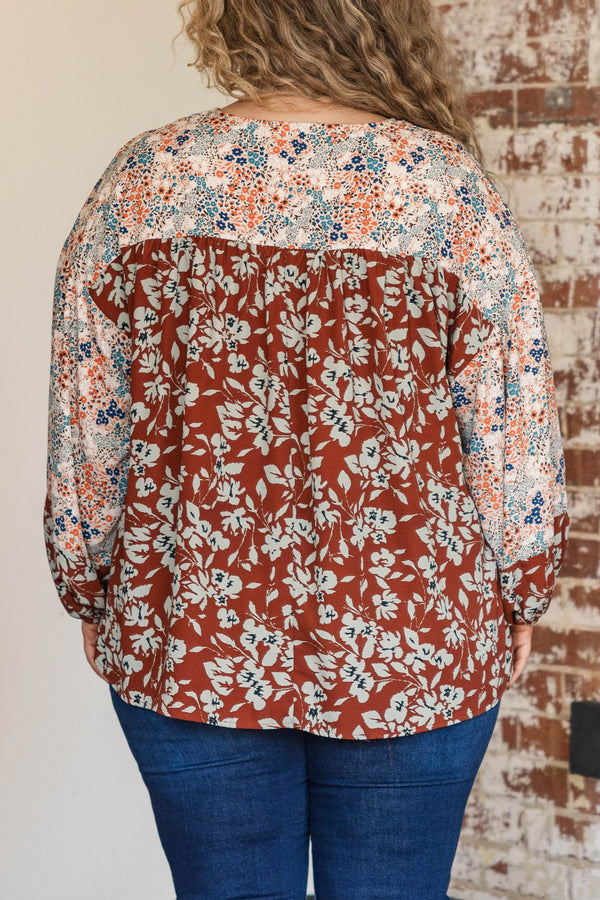 Chic Soul plus size clothing, rust colored top with floral patterned sleeves and larger floral detailing along the bodice