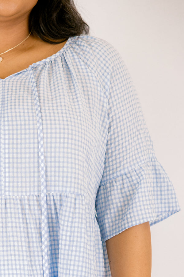 Chic Soul plus size clothing, blue gingham tiered top with short sleeves that have a ruffle flare out at the ends as well as a tassel hanging from each side of the neckline 