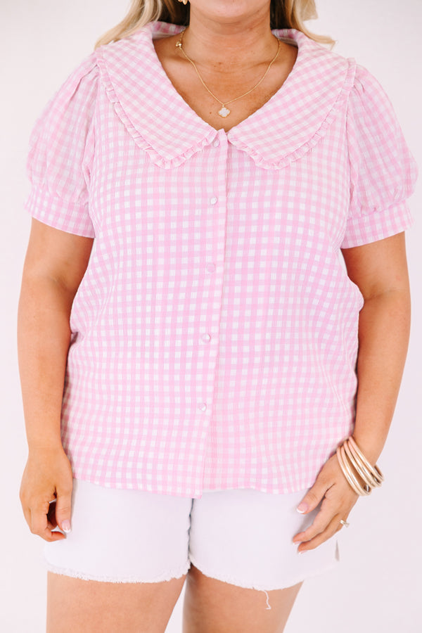 Chic Soul plus size clothing, pink button up top with short sleeves that have cuffs at the end of the sleeves as well as a bib detail on the shoulders that has ruffle detailing and a pink gingham pattern throughout 
