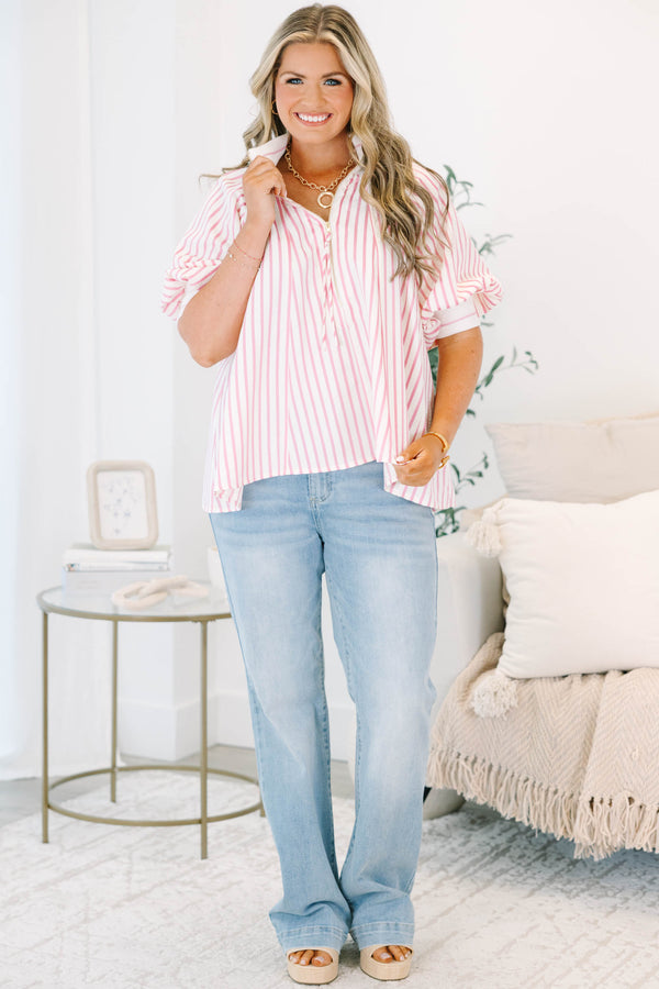 Plus size woman in a pink and white striped flowy top with a quarter-zip and puff sleeves.