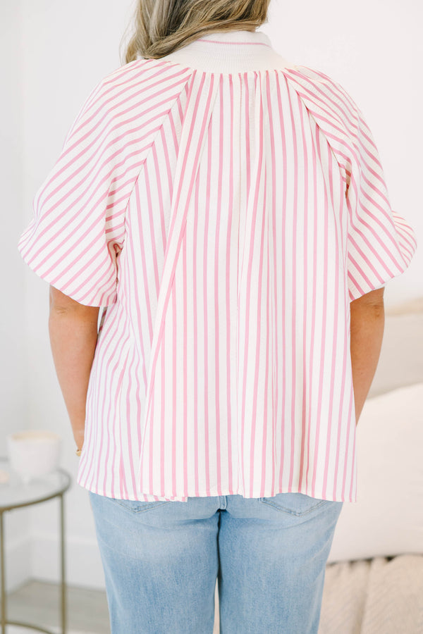 Plus size woman in a pink and white striped flowy top with a quarter-zip and puff sleeves.