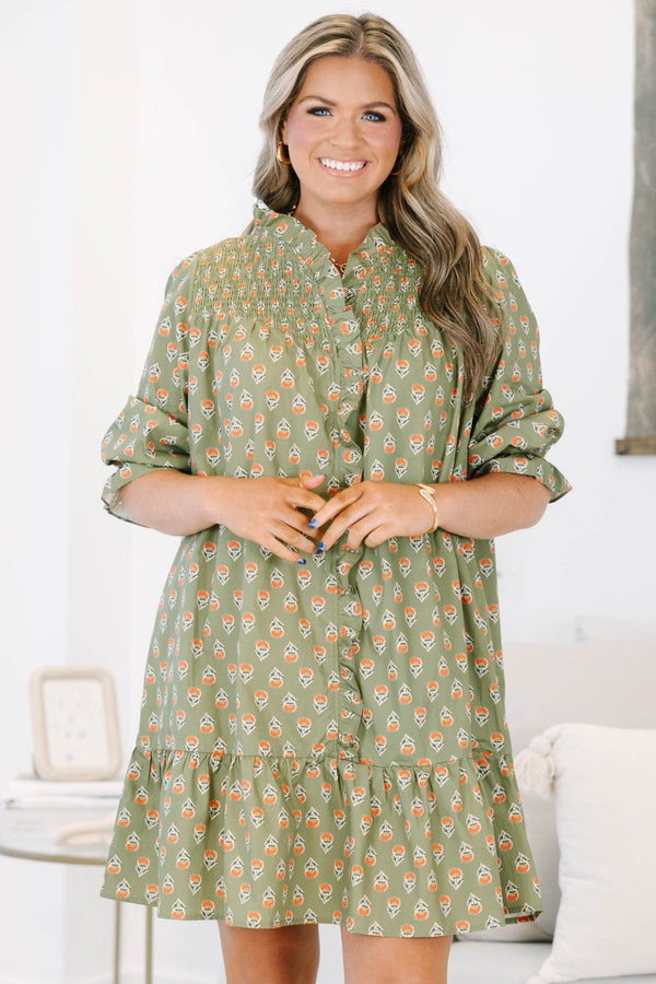 Plus size olive green floral mini dress with a flowy fit, smocked bodice, and ruffle details.