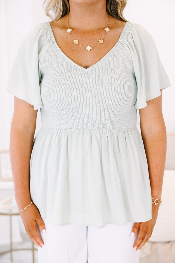 Plus Size sage green smocked peplum top with a V-neckline and flutter sleeves.
