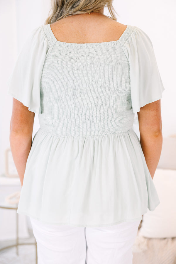 Plus Size sage green smocked peplum top with a V-neckline and flutter sleeves.