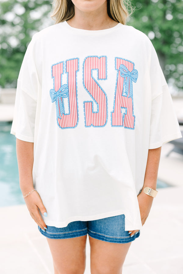 Chic Soul Plus Size Clothing, white short sleeve t-shirt with American flag print text graphic, featuring two blue bows, in front center that says 