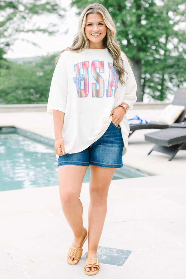 Chic Soul Plus Size Clothing, white short sleeve t-shirt with American flag print text graphic, featuring two blue bows, in front center that says 