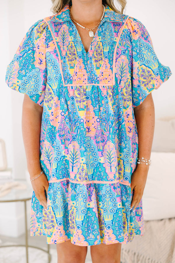 Plus size dress in blue multi color pattern, featuring a flowy fit and vibrant floral pattern.