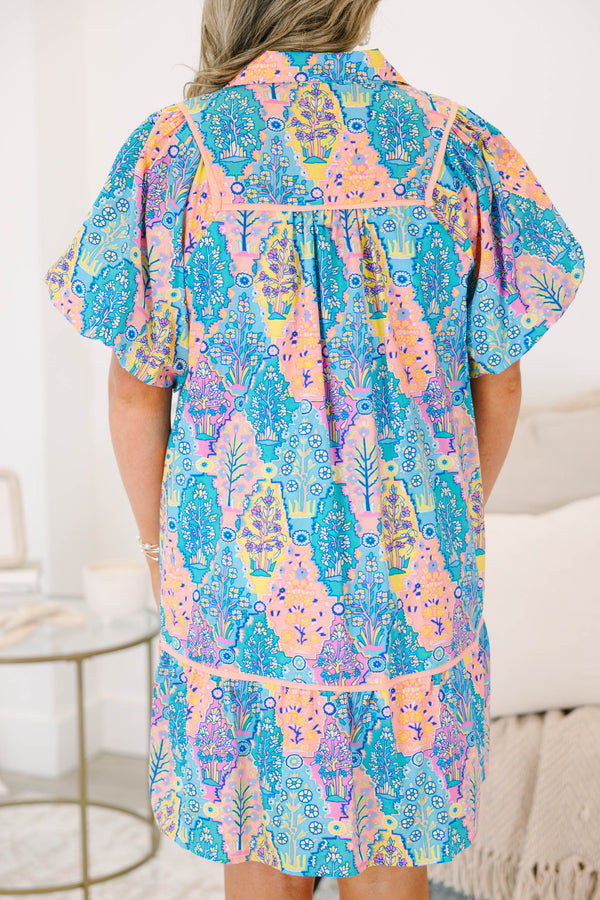 Plus size dress in blue multi color pattern, featuring a flowy fit and vibrant floral pattern.