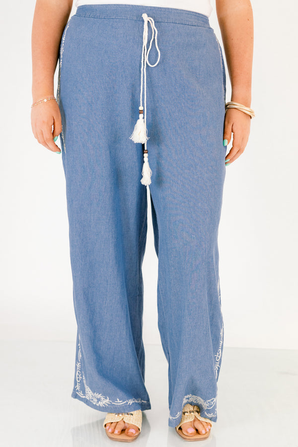 Chic Soul plus size clothing, medium wash denim blue straight leg flowy pants with white embroidery detailing on the ankles and white drawstring tassel tie at the waist