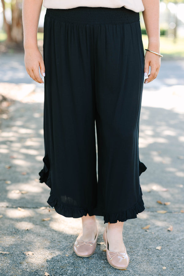 Plus Size black wide-leg rayon pants with a smocked waistband and ruffled hem.