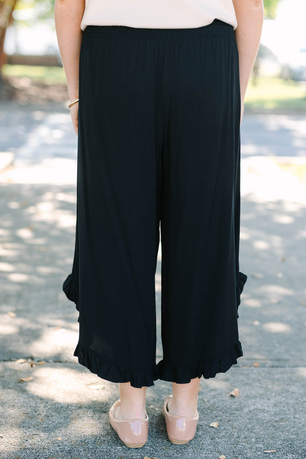 Plus Size black wide-leg rayon pants with a smocked waistband and ruffled hem.