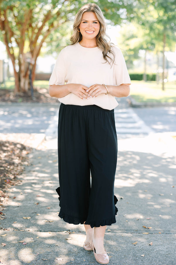 Plus Size black wide-leg rayon pants with a smocked waistband and ruffled hem.